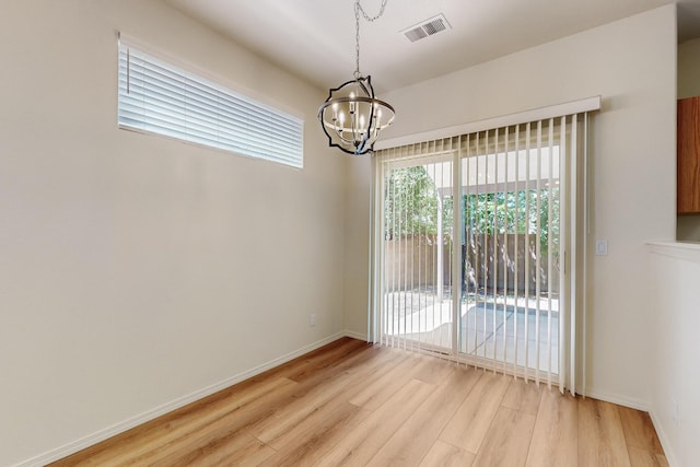 6501 San Antonio Dr NE Unit 2702, Albuquerque, NM 87109 - spare room with a chandelier, light wood finished floors, and baseboards