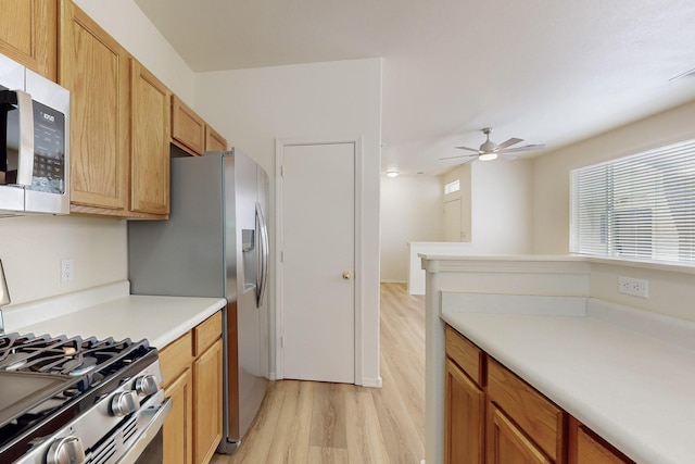 6501 San Antonio Dr NE Unit 2702, Albuquerque, NM 87109 - kitchen featuring stainless steel appliances, light wood-style flooring, light countertops, and ceiling fan