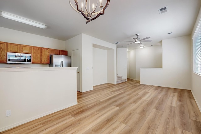 6501 San Antonio Dr NE Unit 2702, Albuquerque, NM 87109 - unfurnished living room with light wood finished floors, a chandelier, ceiling fan, and baseboards
