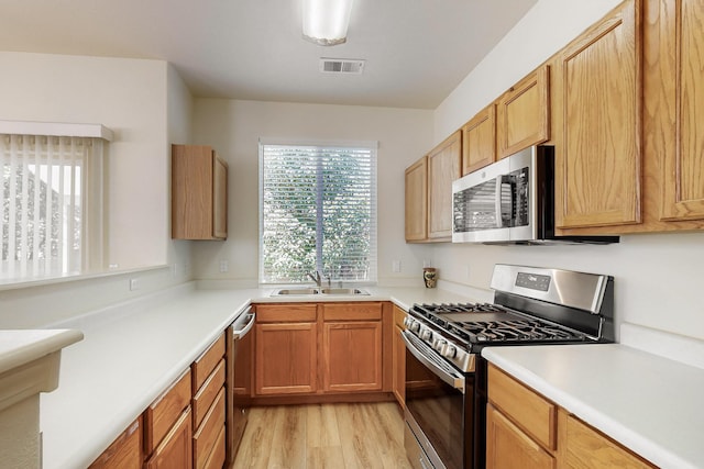 6501 San Antonio Dr NE Unit 2702, Albuquerque, NM 87109 - kitchen featuring appliances with stainless steel finishes, a sink, healthy amount of natural light, and light wood finished floors