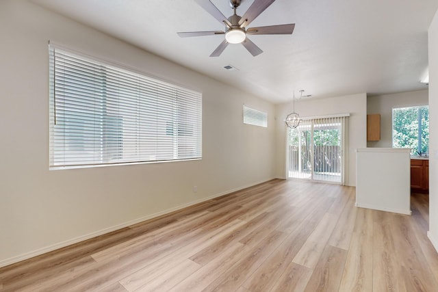6501 San Antonio Dr NE Unit 2702, Albuquerque, NM 87109 - unfurnished living room featuring light wood-style floors, a ceiling fan, a chandelier, and baseboards