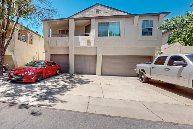 6501 San Antonio Dr NE Unit 2702, Albuquerque, NM 87109 - townhome / multi-family property featuring an attached garage, concrete driveway, stucco siding, and a balcony