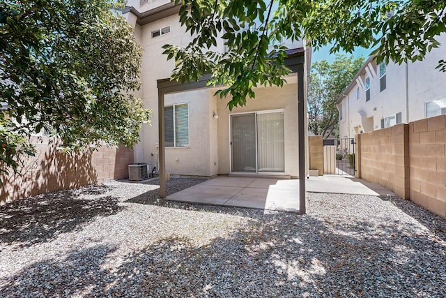 6501 San Antonio Dr NE Unit 2702, Albuquerque, NM 87109 - back of property featuring stucco siding, a gate, central air condition unit, and a patio
