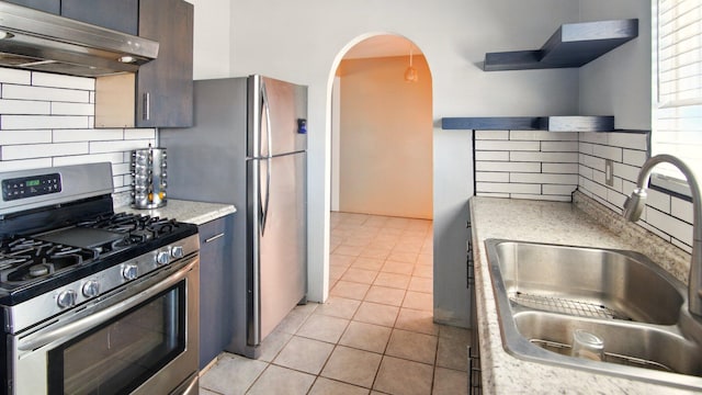558 Apache Loop SW, Rio Rancho, NM 87124 - kitchen featuring appliances with stainless steel finishes, under cabinet range hood, a sink, decorative backsplash, and open shelves