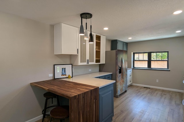 10031 Guadalupe Trl NW Unit A, Albuquerque, NM 87114 - kitchen with stainless steel fridge, baseboards, light wood-style flooring, white cabinets, and recessed lighting