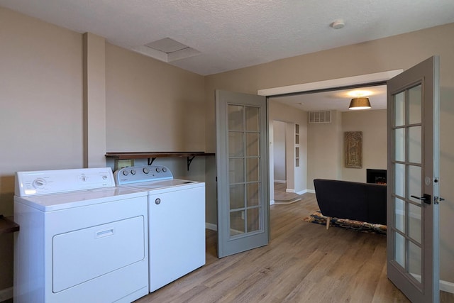 10031 Guadalupe Trl NW Unit A, Albuquerque, NM 87114 - washroom featuring french doors, washer and clothes dryer, light wood finished floors, a textured ceiling, and baseboards