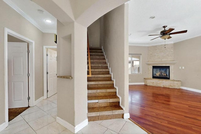 6505 Basket Weaver Ave NW, Albuquerque, NM 87114 - stairs with crown molding, ceiling fan, baseboards, a large fireplace, and wood finished floors
