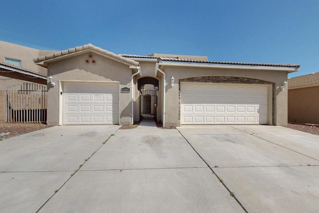 6505 Basket Weaver Ave NW, Albuquerque, NM 87114 - view of front facade featuring stucco siding, concrete driveway, a garage, and a tiled roof