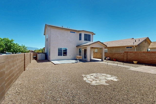 9731 Puccini Trl NW, Albuquerque, NM 87114 - rear view of property featuring a fenced backyard, stucco siding, and a patio area