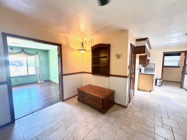 2119 Besler Ln SW, Albuquerque, NM 87105 - corridor featuring healthy amount of natural light, a textured ceiling, and stone tile flooring
