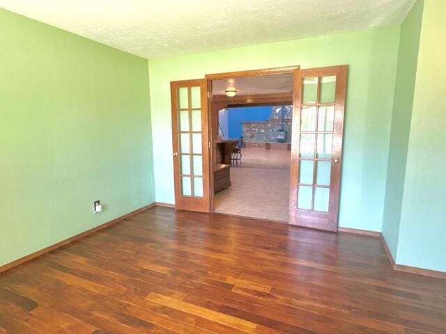 2119 Besler Ln SW, Albuquerque, NM 87105 - empty room with french doors, wood finished floors, baseboards, and a textured ceiling
