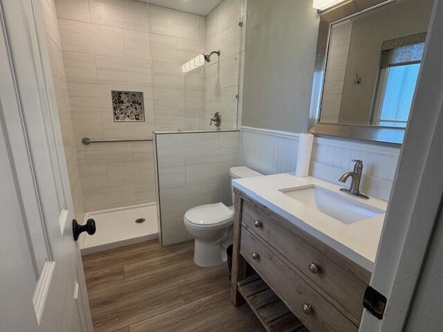 2119 Besler Ln SW, Albuquerque, NM 87105 - full bathroom with toilet, a tile shower, vanity, wood finished floors, and wainscoting