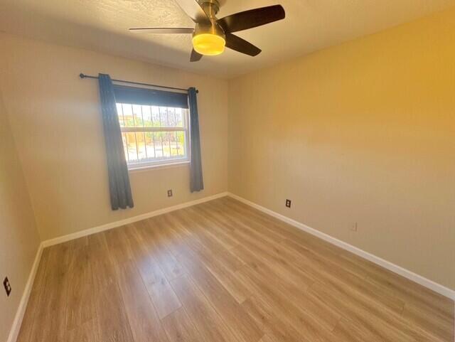 2119 Besler Ln SW, Albuquerque, NM 87105 - unfurnished room with light wood-style floors, baseboards, and a ceiling fan