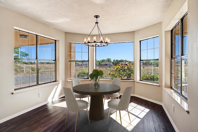 564 Nicklaus Dr SE, Rio Rancho, NM 87124 - dining area featuring a chandelier, wood finished floors, baseboards, healthy amount of natural light, and a textured ceiling
