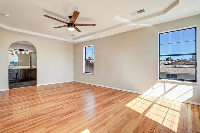 564 Nicklaus Dr SE, Rio Rancho, NM 87124 - empty room featuring a raised ceiling, ceiling fan, wood finished floors, and a smoke detector