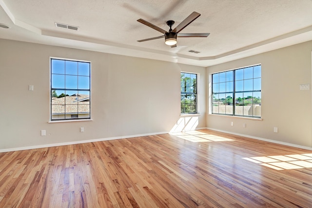 564 Nicklaus Dr SE, Rio Rancho, NM 87124 - empty room with light wood-type flooring, a raised ceiling, baseboards, a textured ceiling, and a ceiling fan