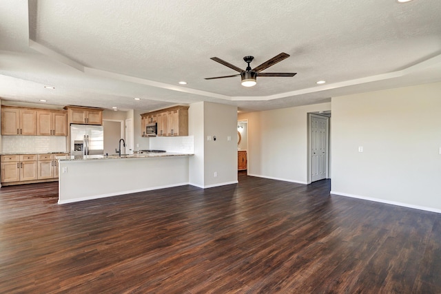 564 Nicklaus Dr SE, Rio Rancho, NM 87124 - unfurnished living room with a tray ceiling, a textured ceiling, dark wood-type flooring, ceiling fan, and baseboards