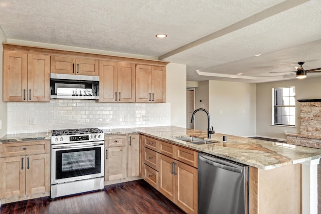 564 Nicklaus Dr SE, Rio Rancho, NM 87124 - kitchen with appliances with stainless steel finishes, a sink, a peninsula, a textured ceiling, and light brown cabinets