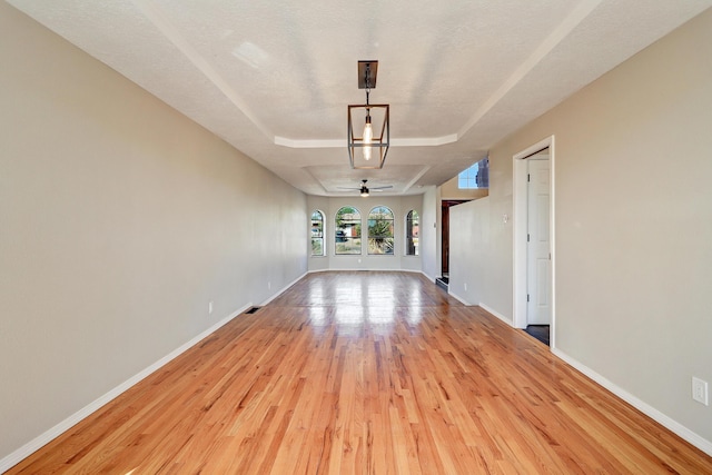 564 Nicklaus Dr SE, Rio Rancho, NM 87124 - unfurnished room with wood finished floors, a tray ceiling, baseboards, and ceiling fan