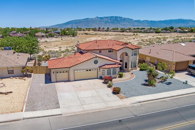 564 Nicklaus Dr SE, Rio Rancho, NM 87124 - mediterranean / spanish home with a garage, a mountain view, a tiled roof, stucco siding, and concrete driveway