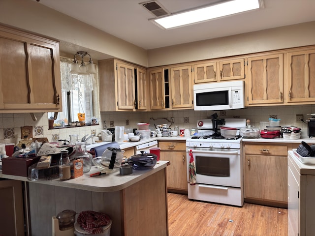 806 Oreja De Oro Dr SE, Rio Rancho, NM 87124 - kitchen with white appliances, light countertops, tasteful backsplash, light wood-type flooring, and a peninsula
