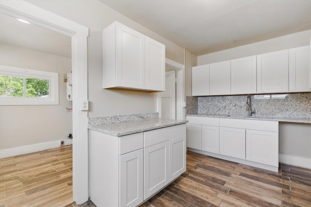 417 8th St NW, Albuquerque, NM 87102 - kitchen featuring wood finished floors, white cabinetry, decorative backsplash, and baseboards