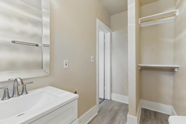 417 8th St NW, Albuquerque, NM 87102 - bathroom featuring wood finished floors, vanity, baseboards, and toilet