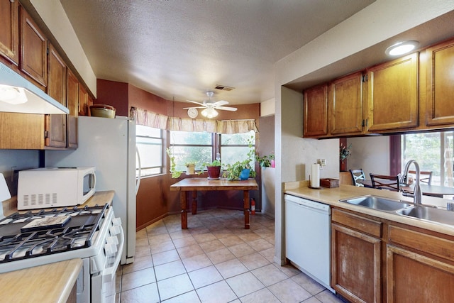 2004 Western Hills Dr NE, Rio Rancho, NM 87124 - kitchen featuring white appliances, a sink, light countertops, healthy amount of natural light, and a textured ceiling