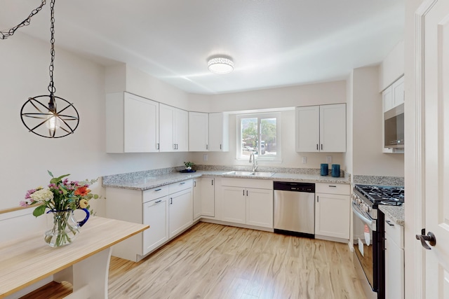 1825 Hiawatha Ct NE, Albuquerque, NM 87112 - kitchen with stainless steel appliances, a sink, light wood-style floors, and white cabinetry