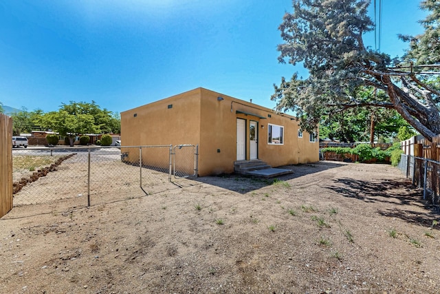 1825 Hiawatha Ct NE, Albuquerque, NM 87112 - rear view of property featuring stucco siding, a fenced backyard, and a gate