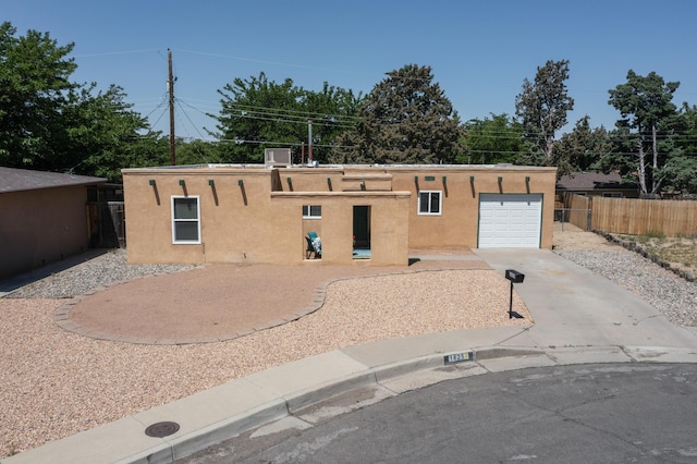 1825 Hiawatha Ct NE, Albuquerque, NM 87112 - pueblo-style home featuring a garage, stucco siding, and concrete driveway