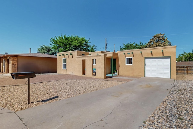 1825 Hiawatha Ct NE, Albuquerque, NM 87112 - pueblo revival-style home featuring stucco siding, concrete driveway, and an attached garage