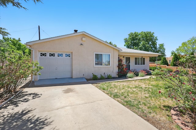 9722 Apache Ave NE, Albuquerque, NM 87112 - view of front of house with stucco siding, concrete driveway, a garage, and a front lawn