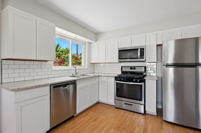 9722 Apache Ave NE, Albuquerque, NM 87112 - kitchen featuring stainless steel appliances, a sink, white cabinetry, and backsplash