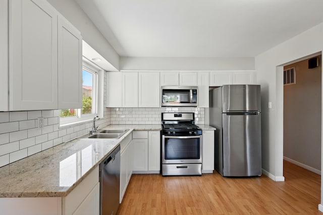 9722 Apache Ave NE, Albuquerque, NM 87112 - kitchen featuring appliances with stainless steel finishes, a sink, white cabinetry, and decorative backsplash