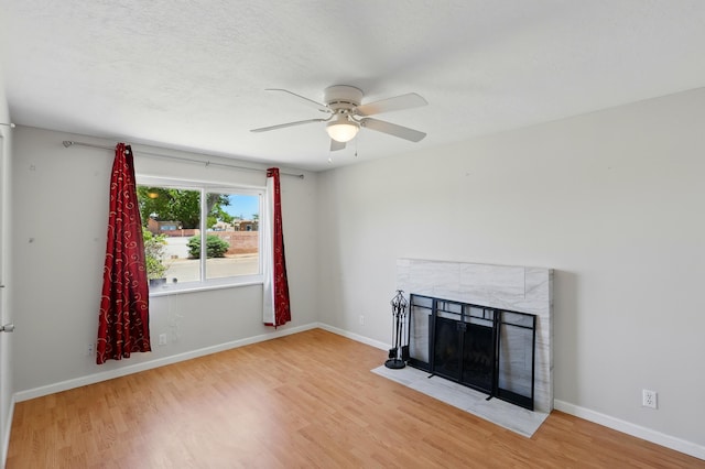 9722 Apache Ave NE, Albuquerque, NM 87112 - unfurnished living room with a ceiling fan, wood finished floors, a tile fireplace, and baseboards