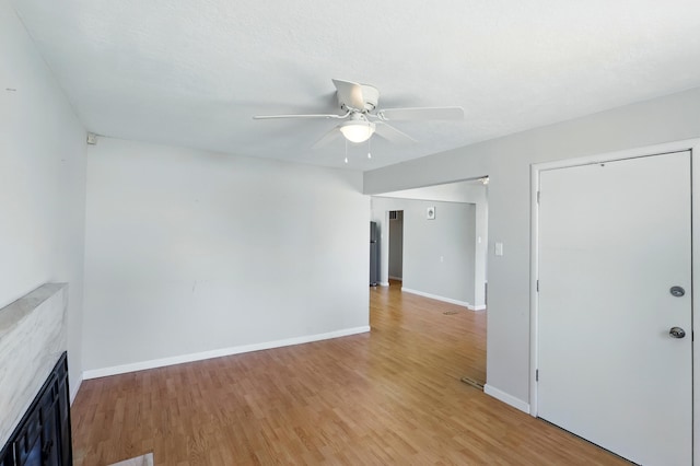 9722 Apache Ave NE, Albuquerque, NM 87112 - unfurnished living room featuring ceiling fan, light wood-style flooring, and a fireplace
