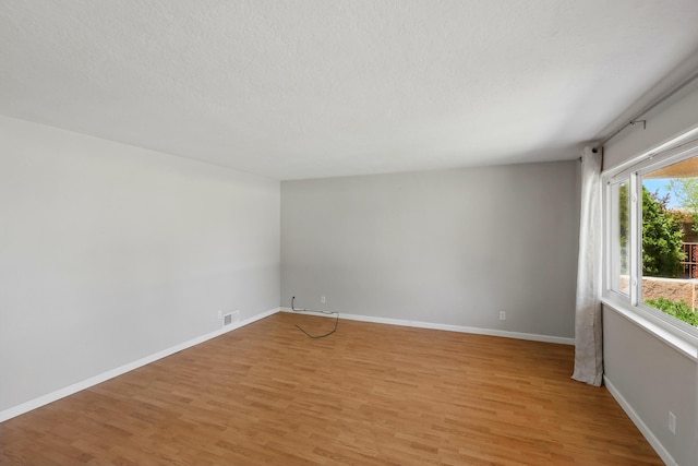 9722 Apache Ave NE, Albuquerque, NM 87112 - unfurnished room featuring light wood-type flooring and a textured ceiling