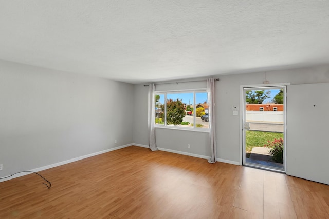 9722 Apache Ave NE, Albuquerque, NM 87112 - empty room with light wood finished floors, a textured ceiling, and baseboards
