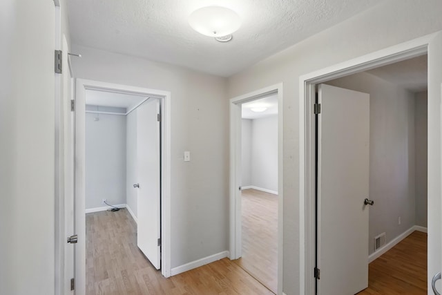 9722 Apache Ave NE, Albuquerque, NM 87112 - hall with light wood finished floors, baseboards, and a textured ceiling