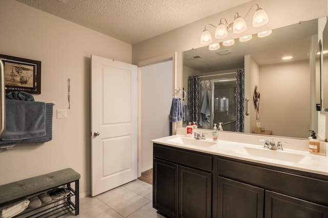 2336 Del Timbre Ln SW, Albuquerque, NM 87121 - full bath featuring double vanity, tile patterned floors, a textured ceiling, and curtained shower