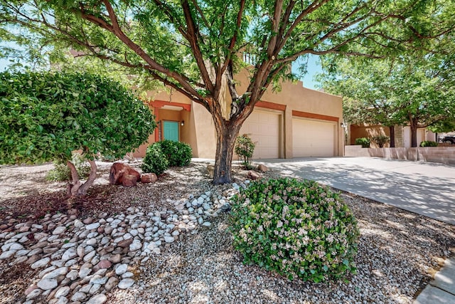 5124 Pyrite Pl NW, Albuquerque, NM 87114 - pueblo-style house with stucco siding, an attached garage, and concrete driveway