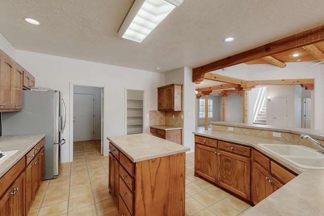 5124 Pyrite Pl NW, Albuquerque, NM 87114 - kitchen with a sink, a textured ceiling, light countertops, light tile patterned flooring, and a center island