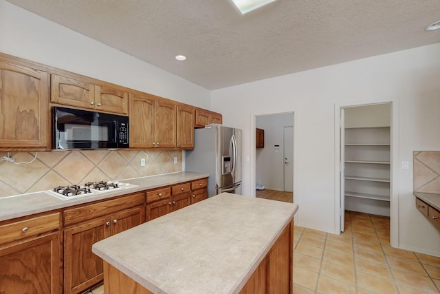 5124 Pyrite Pl NW, Albuquerque, NM 87114 - kitchen featuring black microwave, stainless steel fridge with ice dispenser, white stovetop, tasteful backsplash, and light countertops