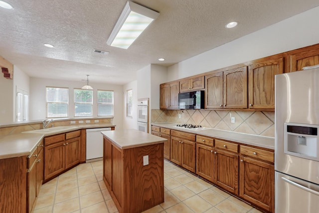 5124 Pyrite Pl NW, Albuquerque, NM 87114 - kitchen featuring white appliances, a center island, a textured ceiling, backsplash, and a sink
