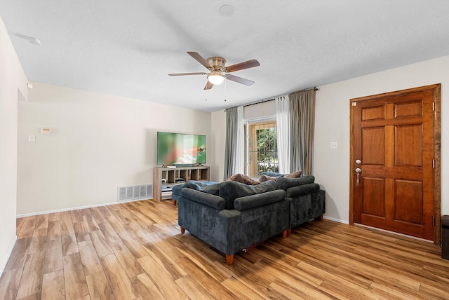 7609 Hannett Ave NE, Albuquerque, NM 87110 - living room featuring light wood finished floors, ceiling fan, a textured ceiling, and baseboards