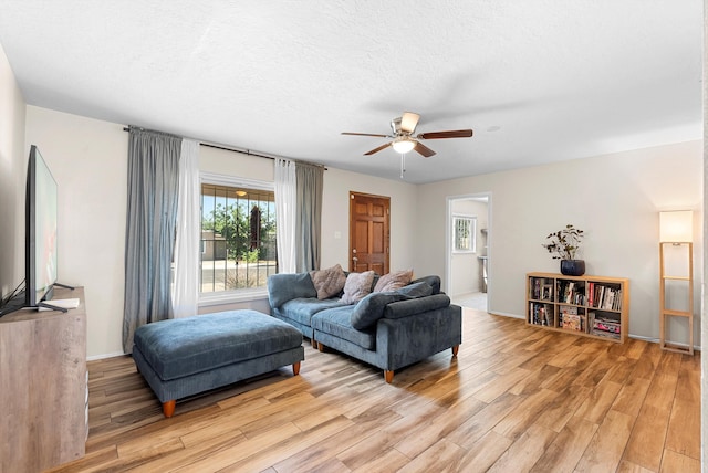 7609 Hannett Ave NE, Albuquerque, NM 87110 - living area with light wood finished floors, a ceiling fan, baseboards, and a textured ceiling