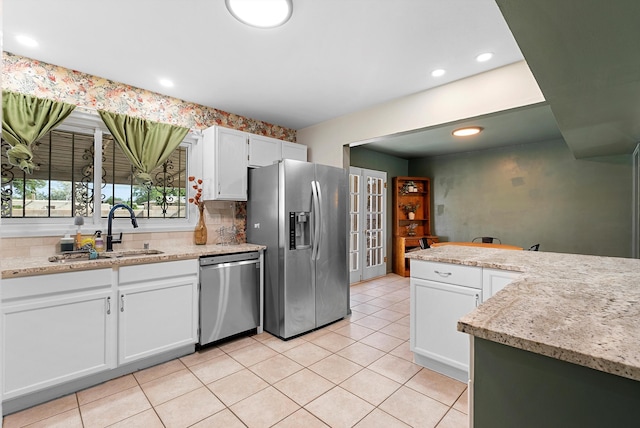 7609 Hannett Ave NE, Albuquerque, NM 87110 - kitchen with appliances with stainless steel finishes, a sink, white cabinets, light tile patterned floors, and recessed lighting