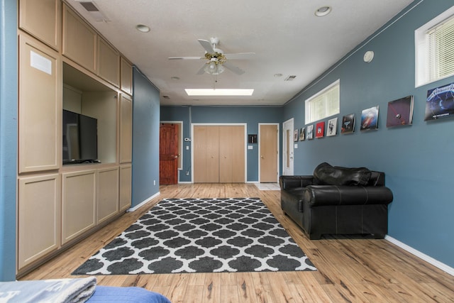 8215 Corona Ave NE, Albuquerque, NM 87122 - living room featuring a ceiling fan, light wood finished floors, baseboards, and plenty of natural light