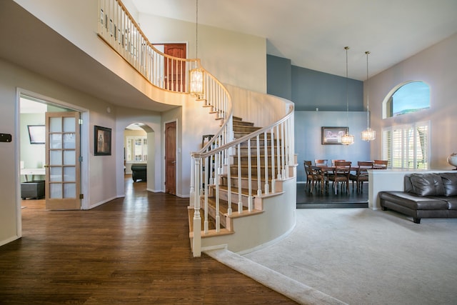 8215 Corona Ave NE, Albuquerque, NM 87122 - foyer entrance featuring a towering ceiling, stairway, arched walkways, a chandelier, and wood finished floors